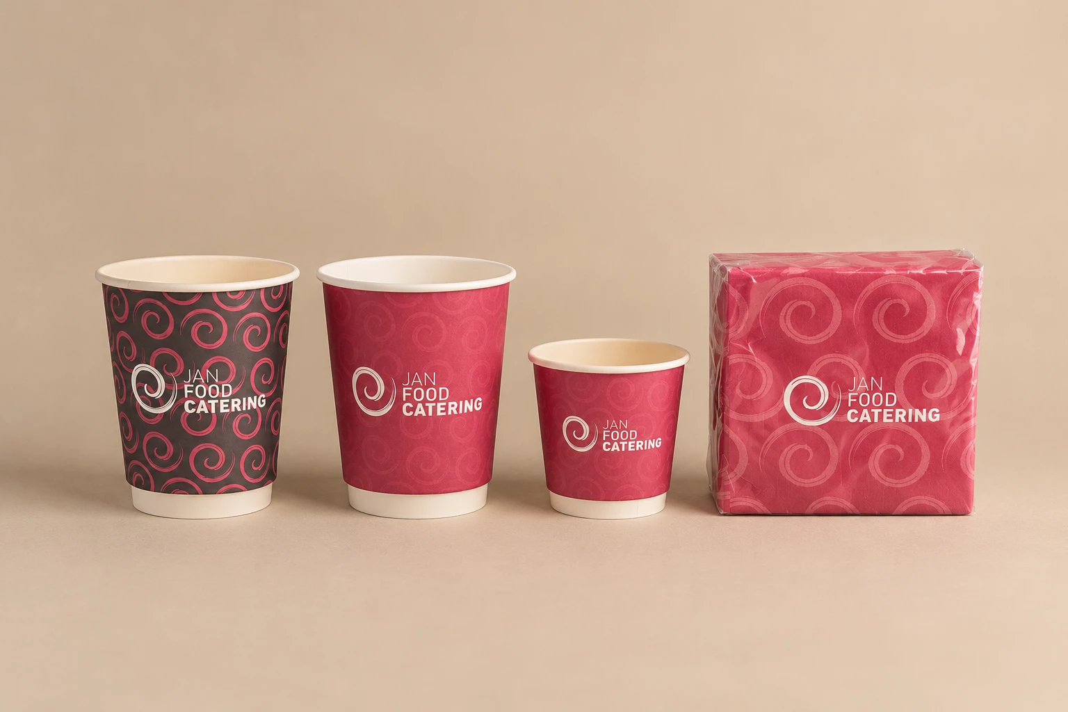 Tres vasos en dos tamaños y un paquete de servilletas con el logotipo de Jan Food Catering